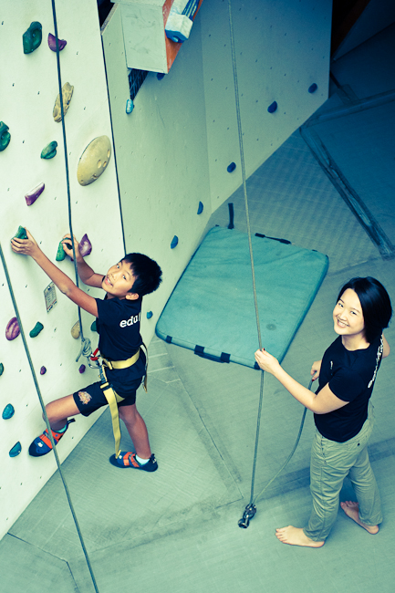 Students taking part in a wall-climbing enrichment activity at Climb Central.