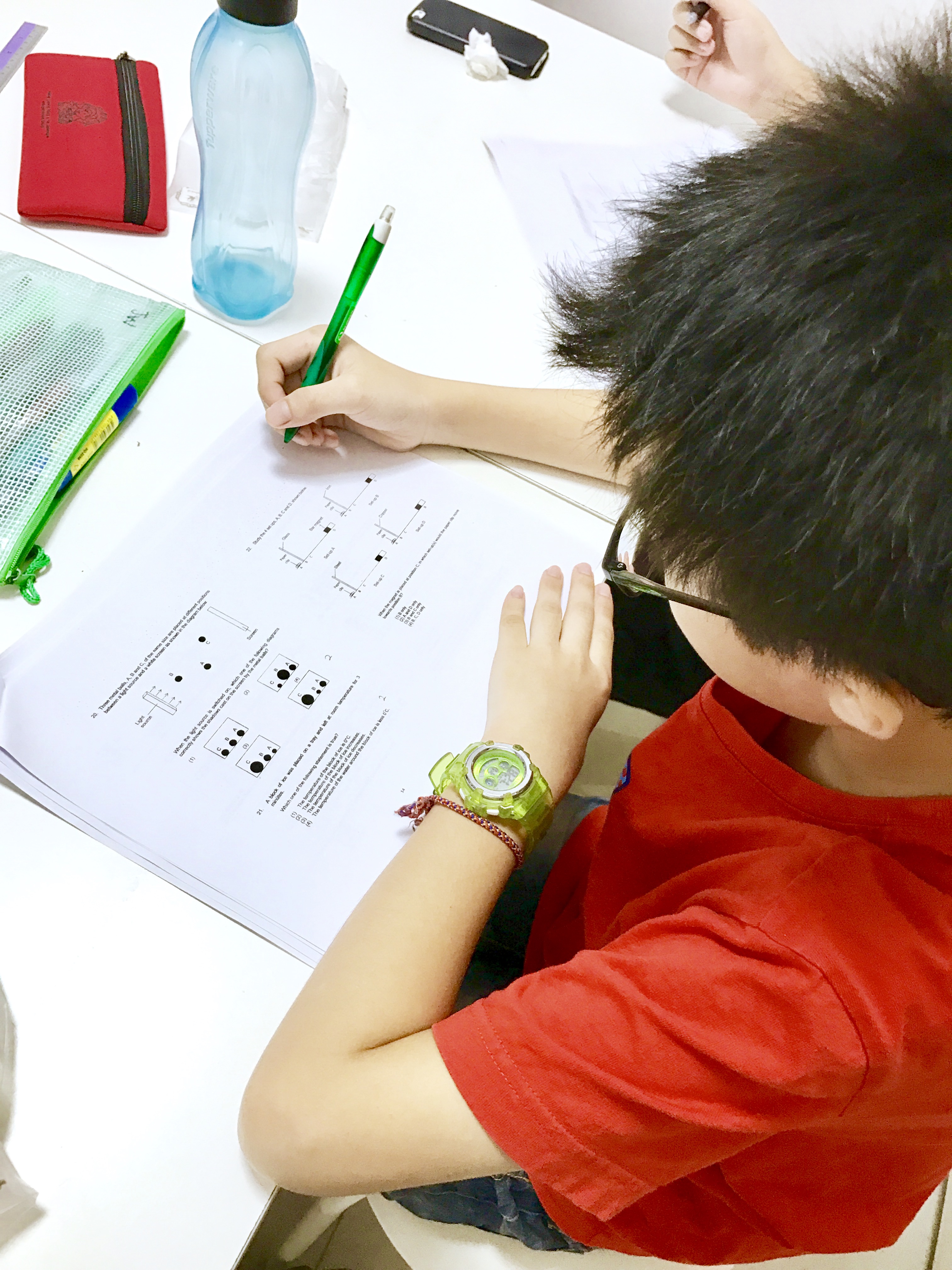 Students working through science questions in a Punggol tuition class.