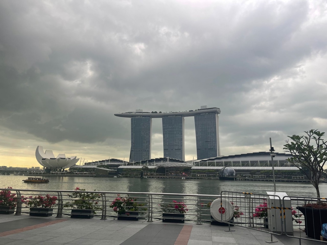 Marina Bay with Marina Bay Sands beneath dark storm clouds in Singapore.