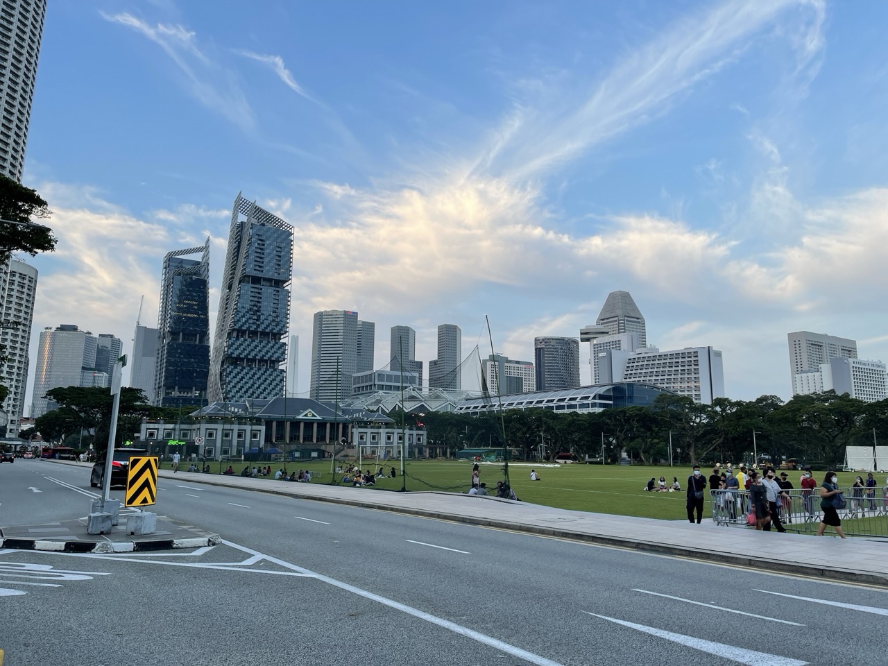 The Padang with people relaxing and the Singapore skyline in the background.