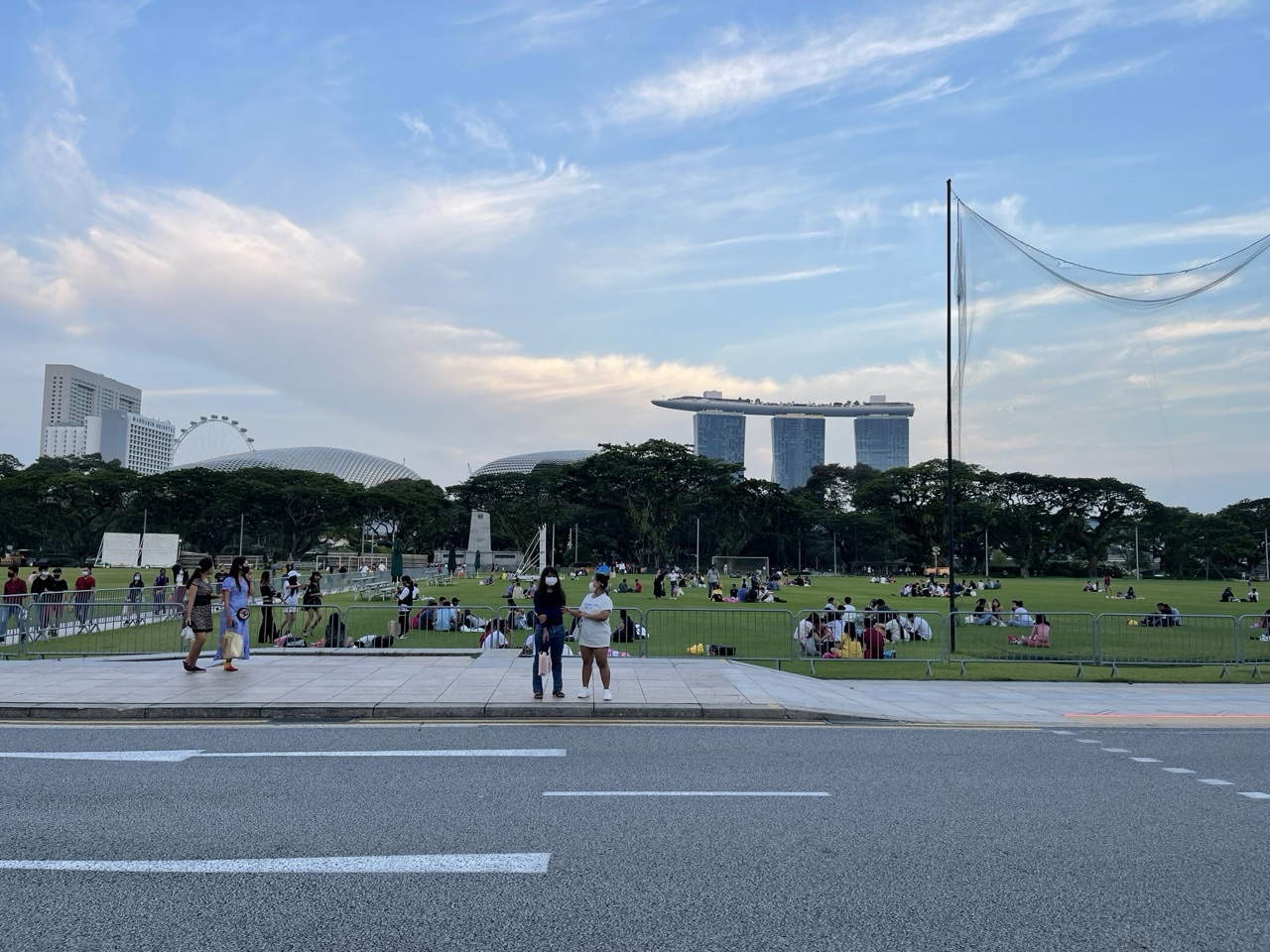 People relaxing at the Padang with Singapore's skyline in the background.