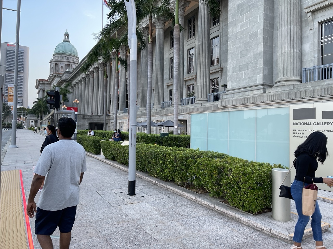 National Gallery Singapore beside the Padang with visitors and the Singapore skyline in view.