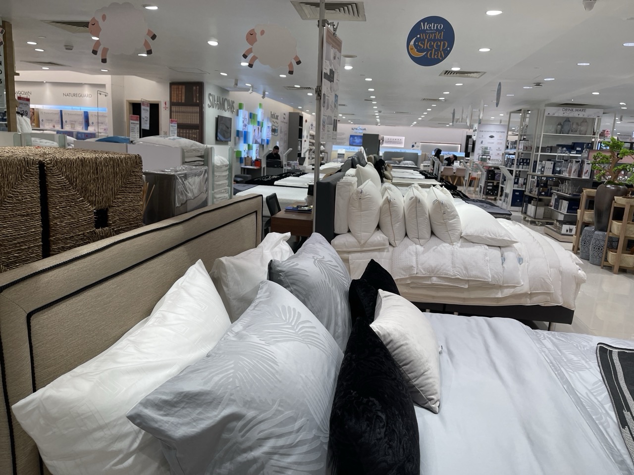 New beds and bed linen displayed for sale inside a retail store.