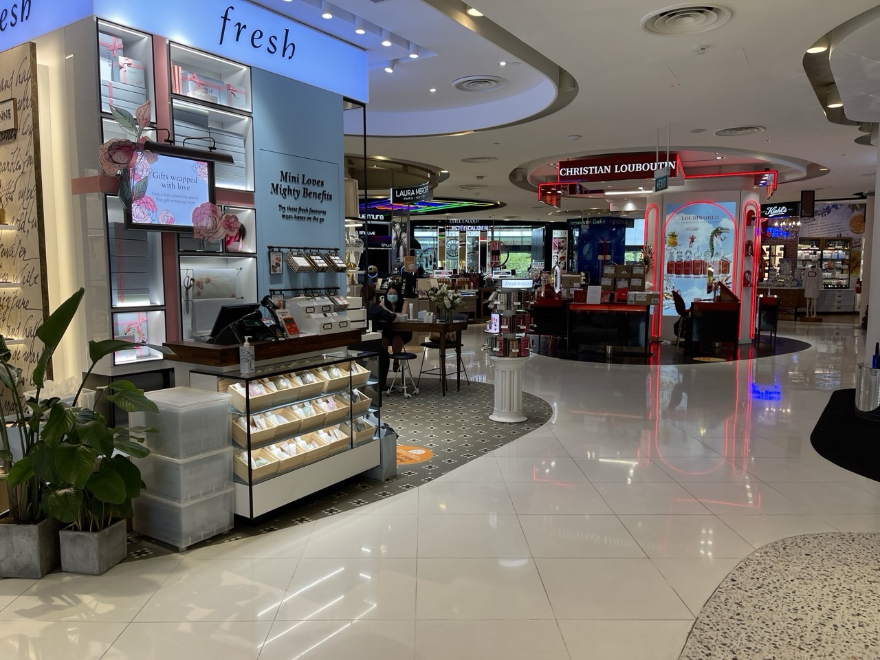 Makeup and skincare counters inside a shopping mall.
