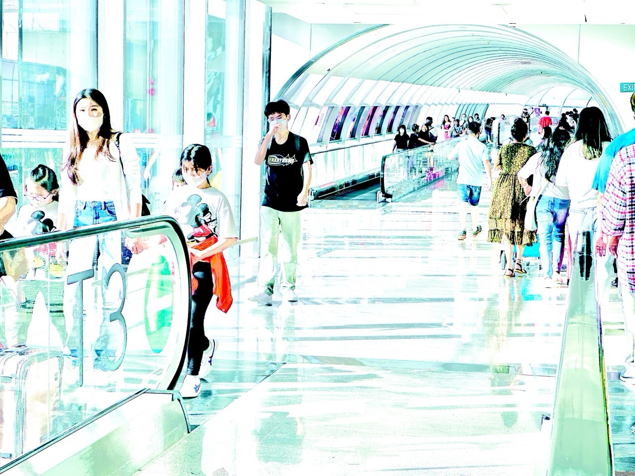Travellers and shoppers using the link between Changi Airport Terminal 3 and Jewel Changi Airport.