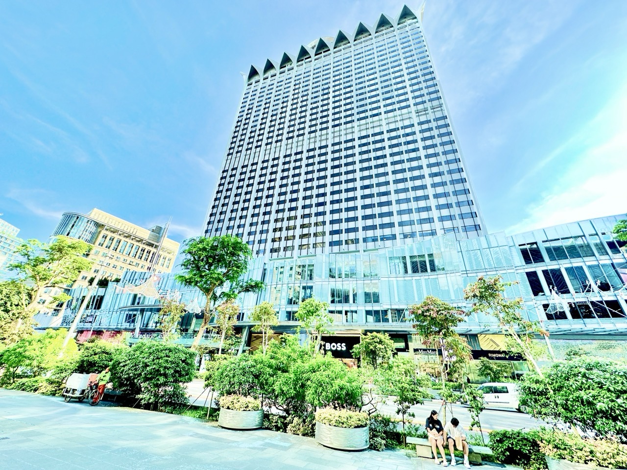 Hilton Singapore Orchard and Mandarin Gallery with shoppers and street-cleaning activity along Orchard Road.