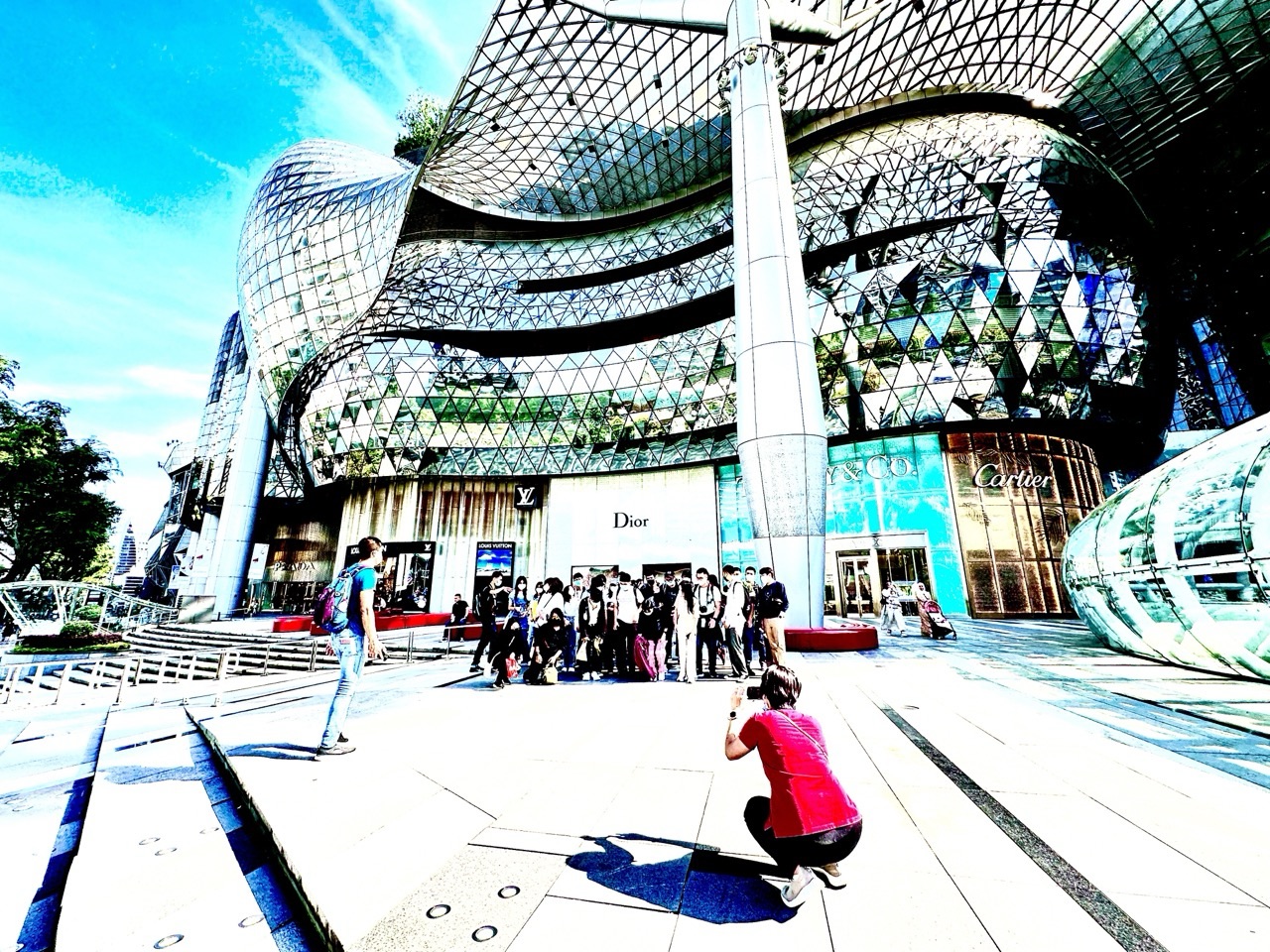 Tourists taking a group photograph outside ION Orchard in Singapore.