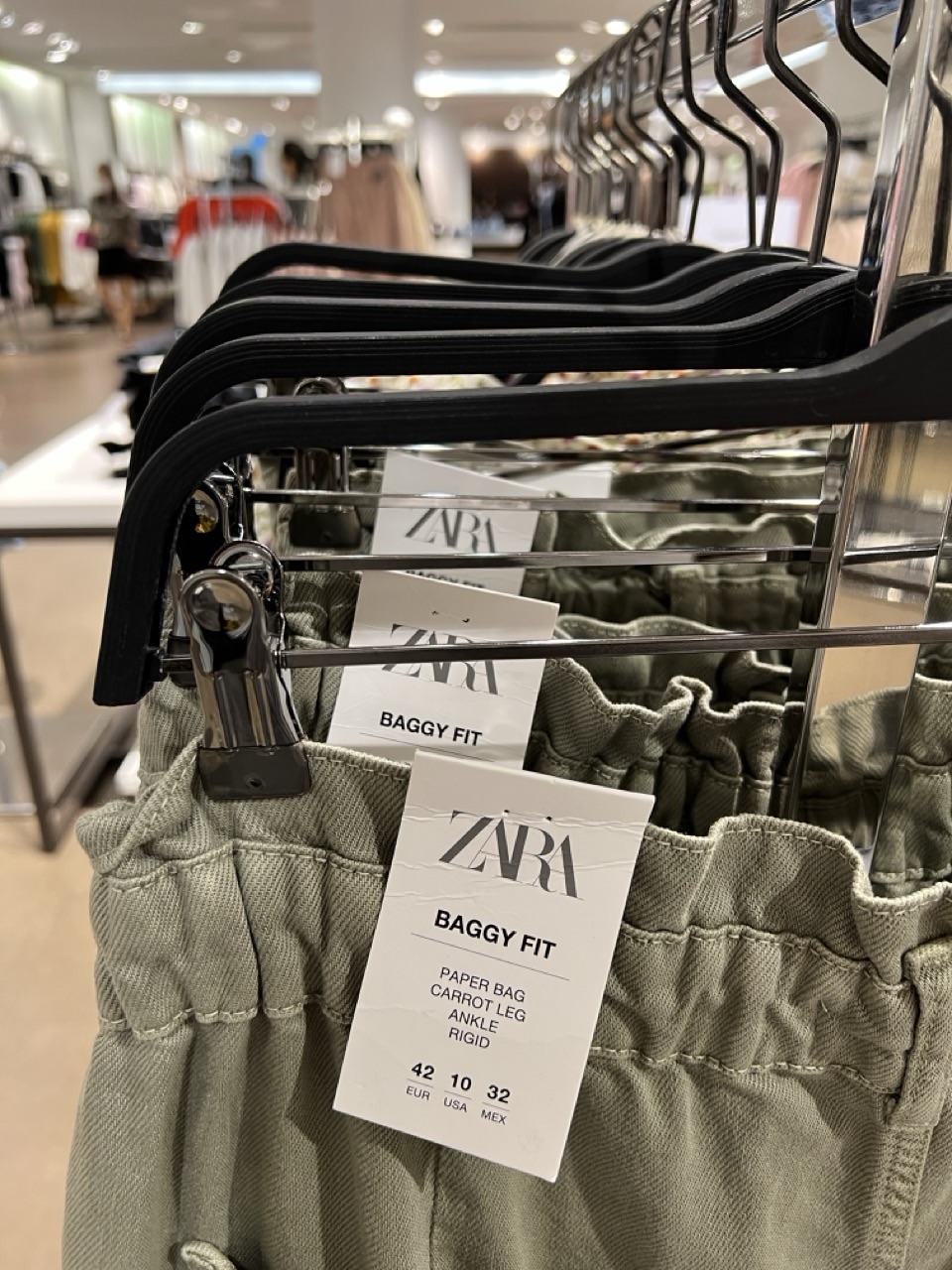 Close-up texture of trousers hanging on a clothing rack.