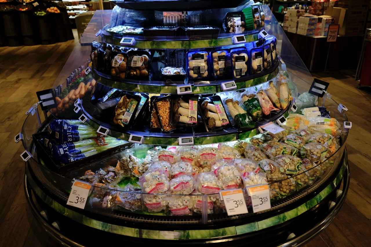 Packaged mushrooms displayed with visible price labels.