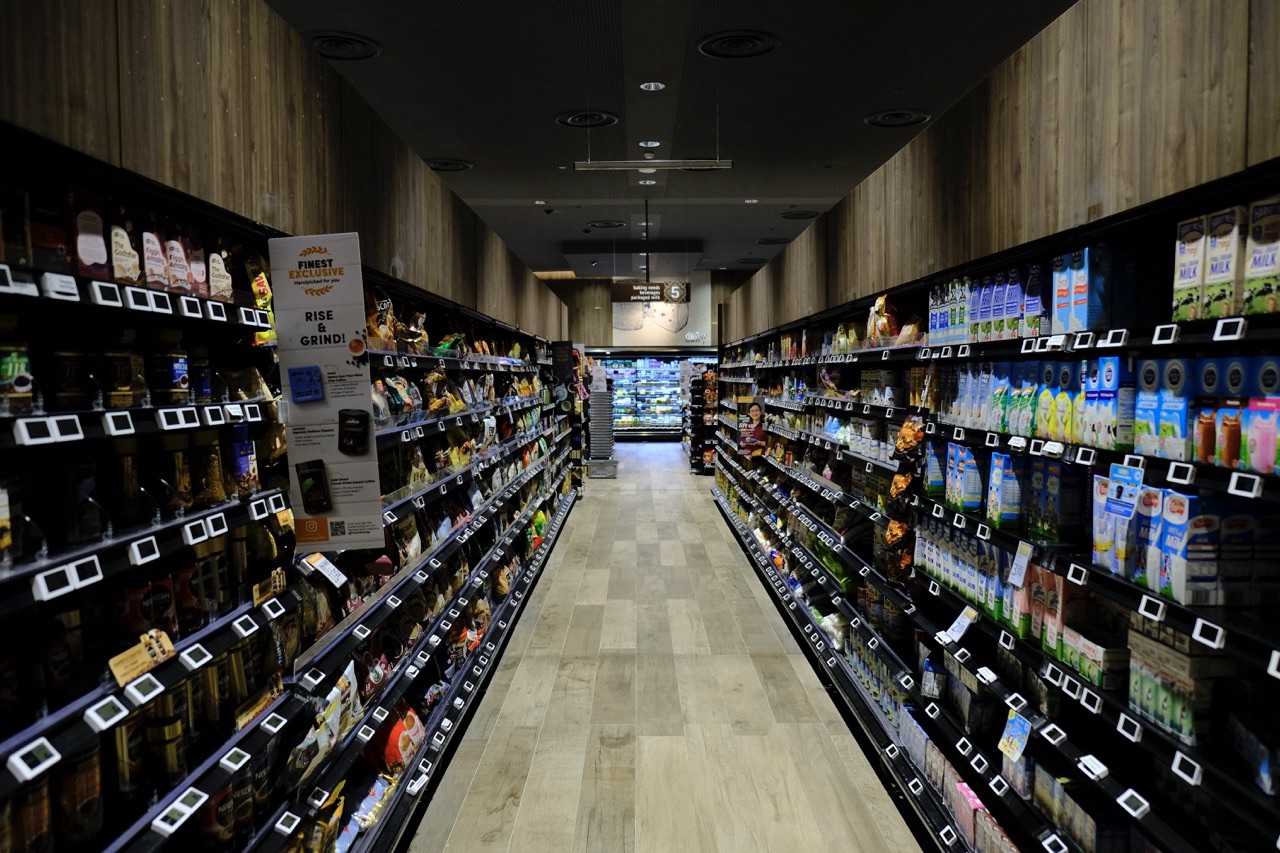 Supermarket shelves stocked with food products and milk.