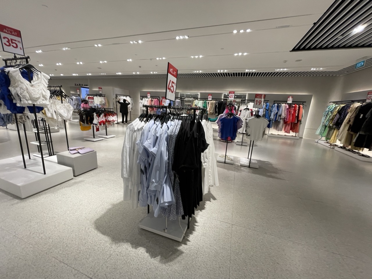 Women's clothing displayed in a retail store with price tags.