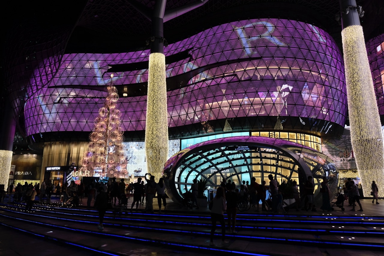 ION Orchard exterior illuminated at night with Christmas lighting.