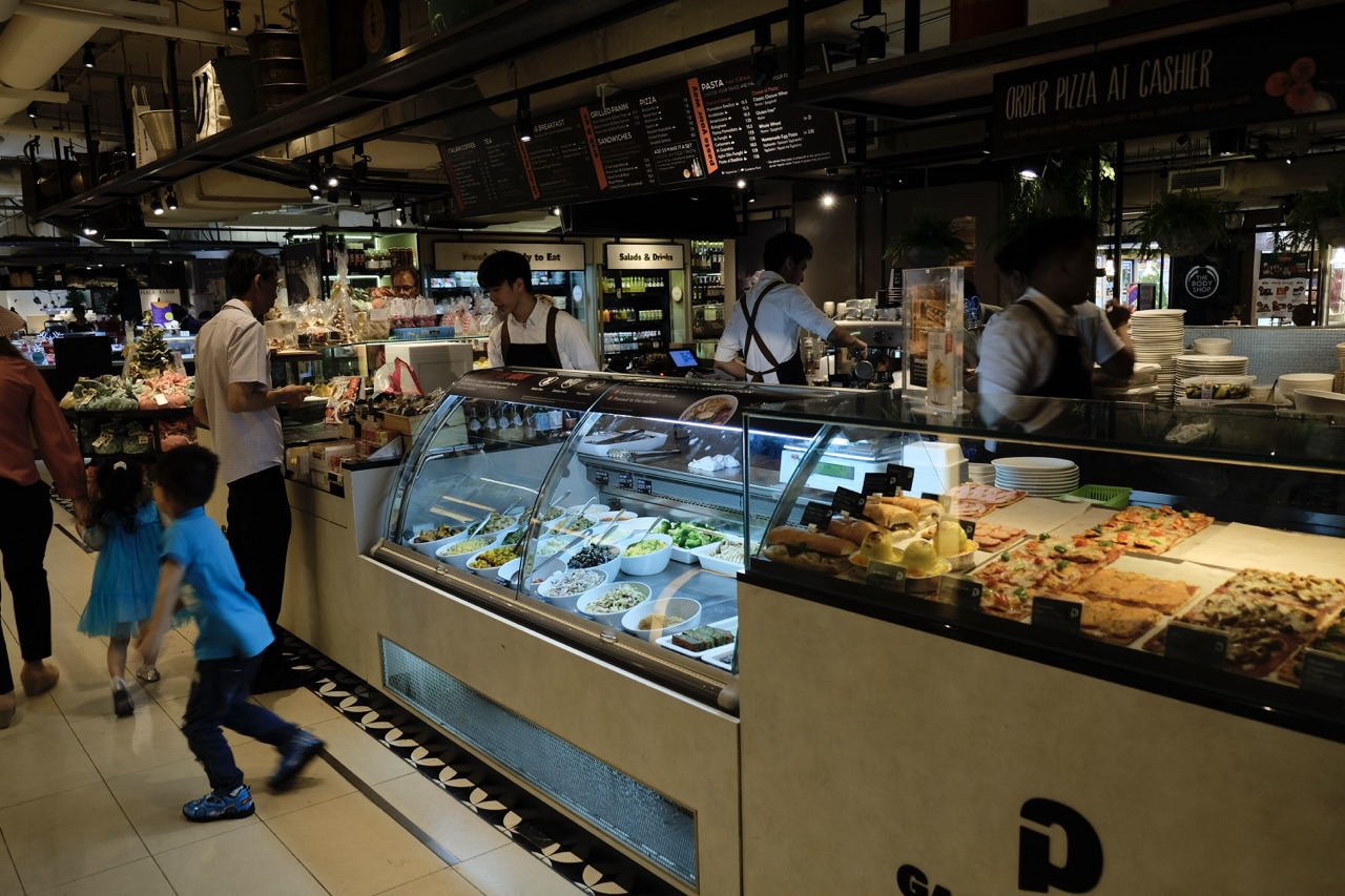 Café food counters with a customer paying at the cashier.