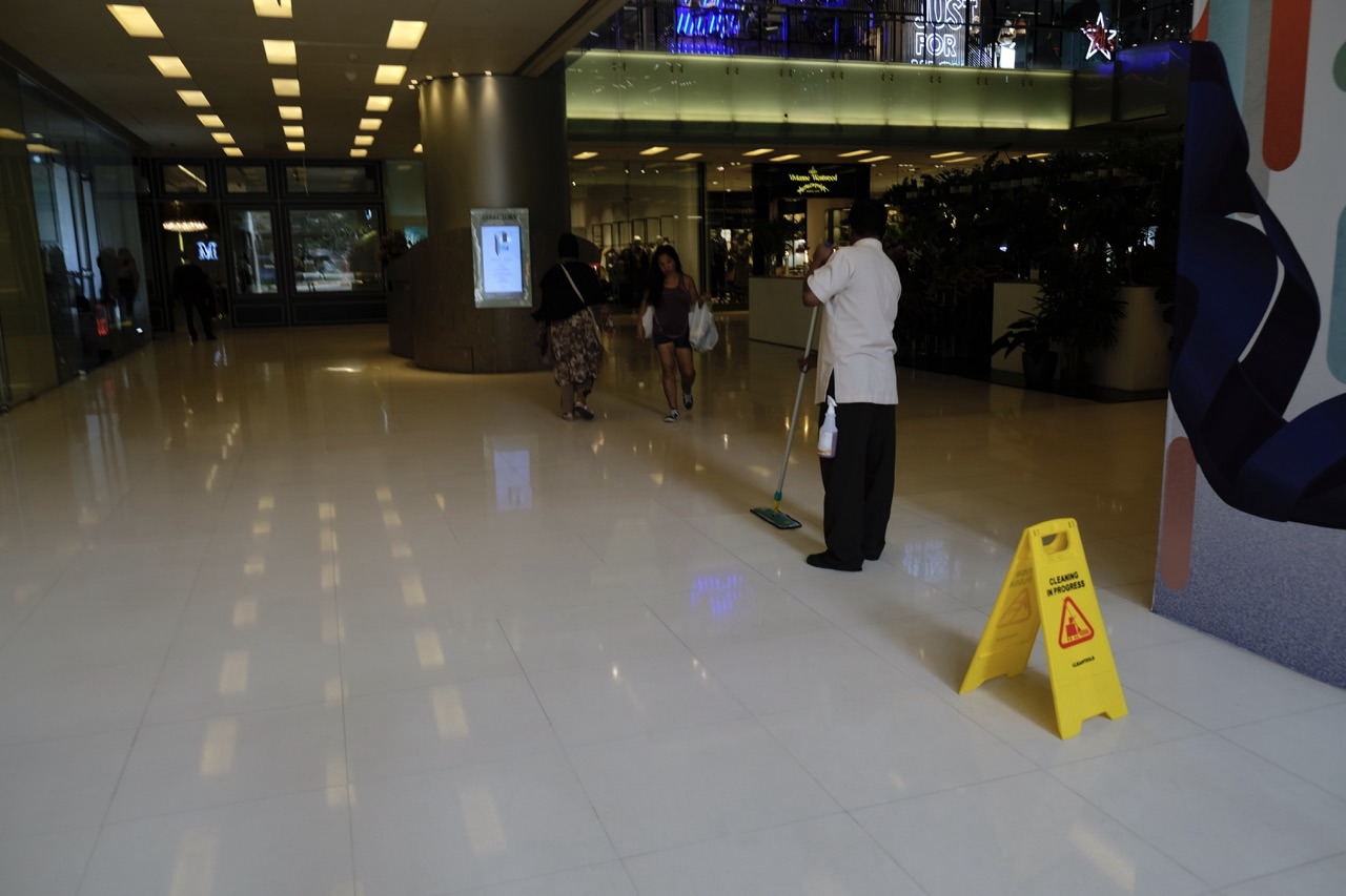 Cleaner working on the floor inside Scotts Square in Singapore.