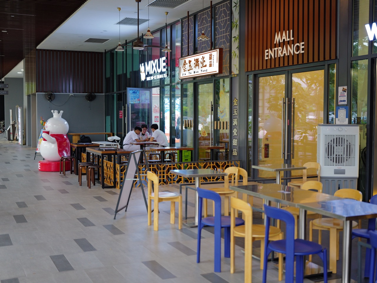Schoolchildren seated and eating outside food outlets at The Linq in Bukit Timah.