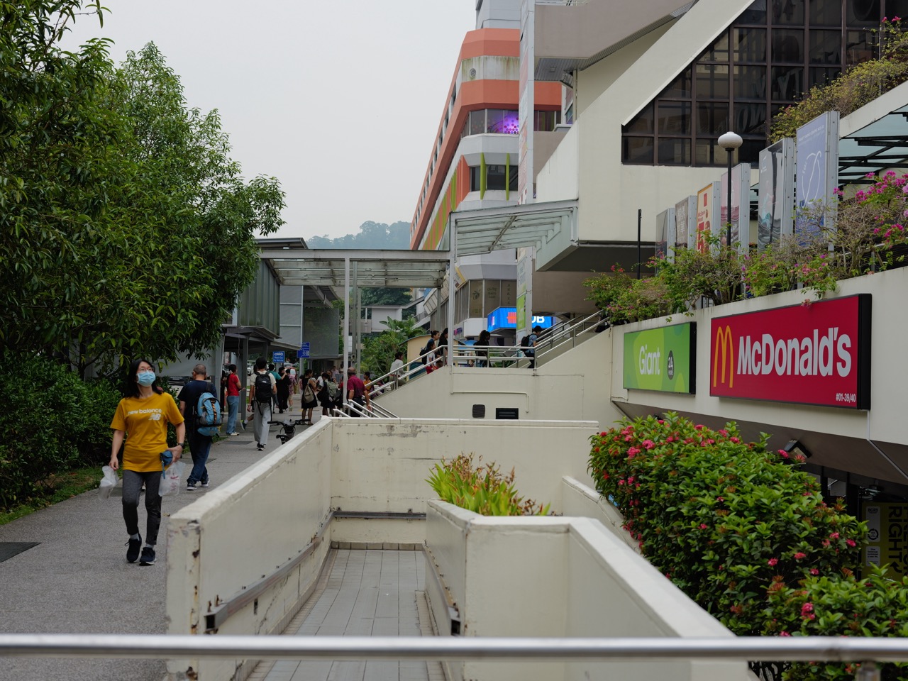 Beauty World MRT station exit with pedestrians and shops outside Beauty World Centre.