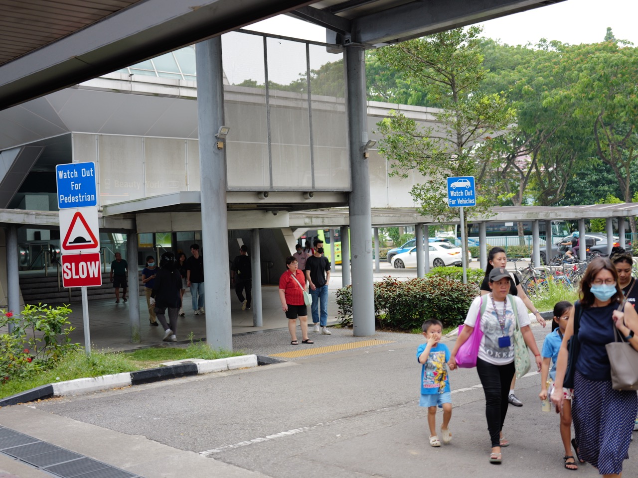 Families and children using the escalator and stairs at Beauty World MRT station.