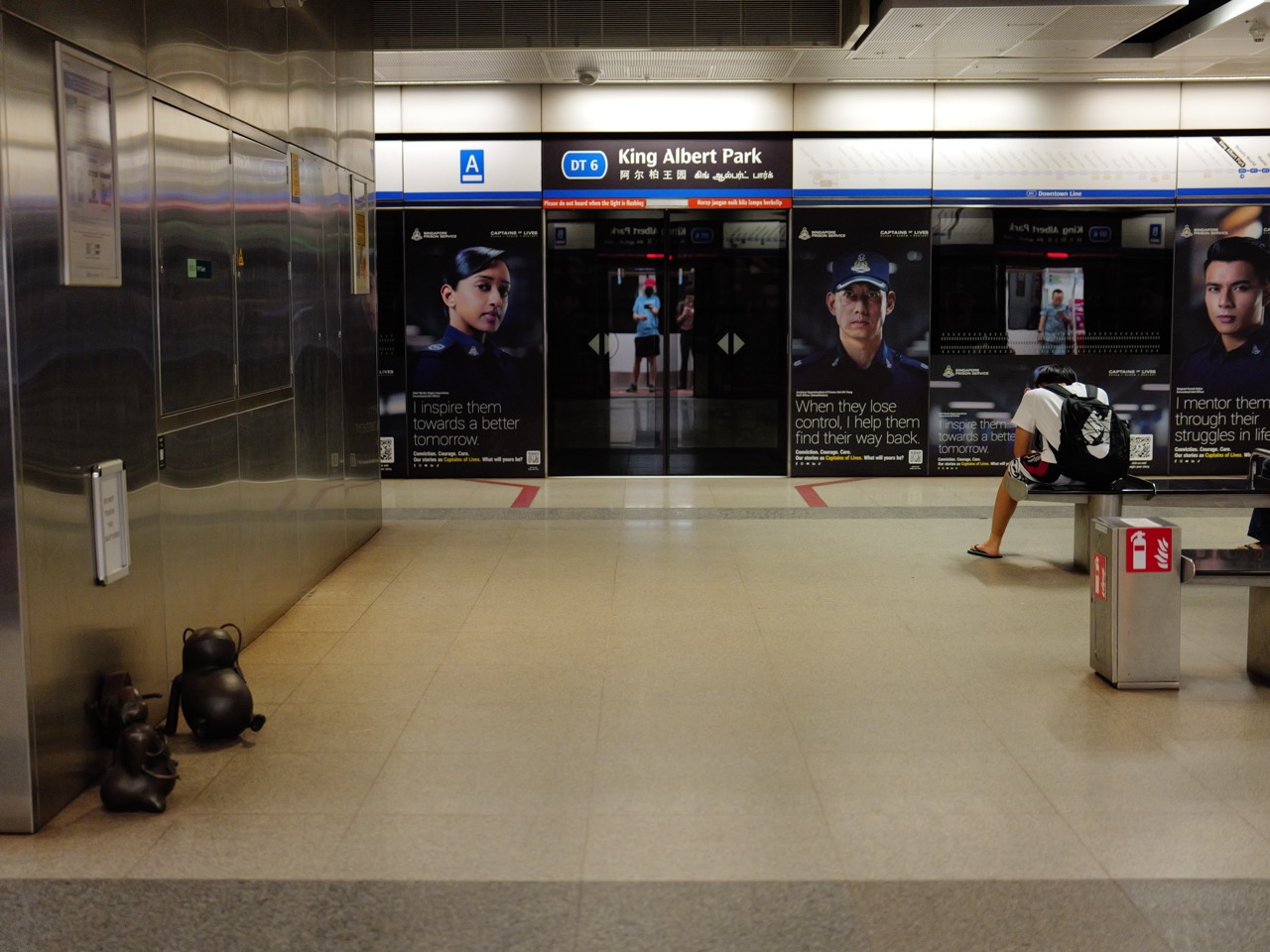 People sitting inside King Albert Park MRT station on Singapore's Downtown Line.