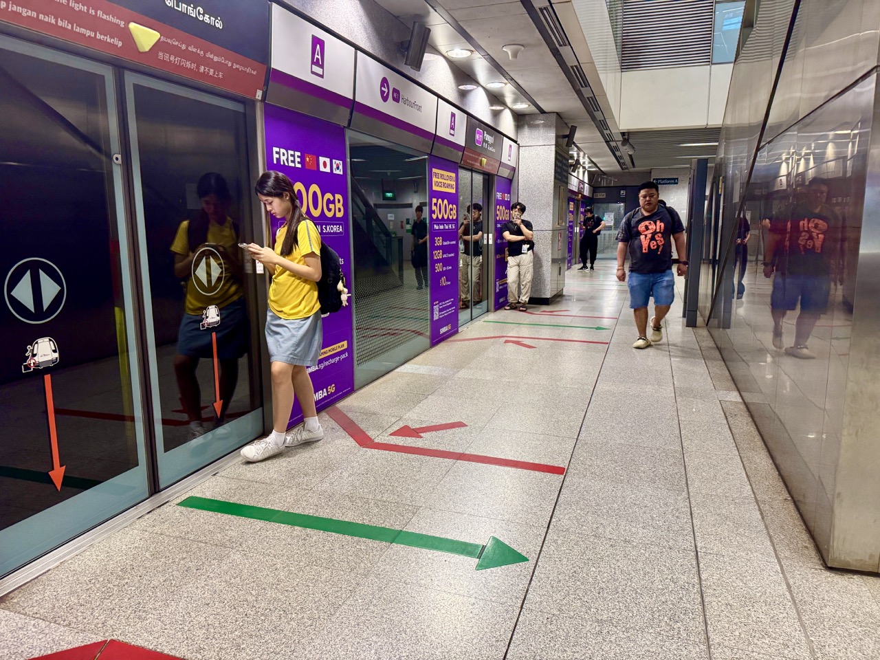 Student and other passengers waiting for a train at Punggol MRT station in the evening.