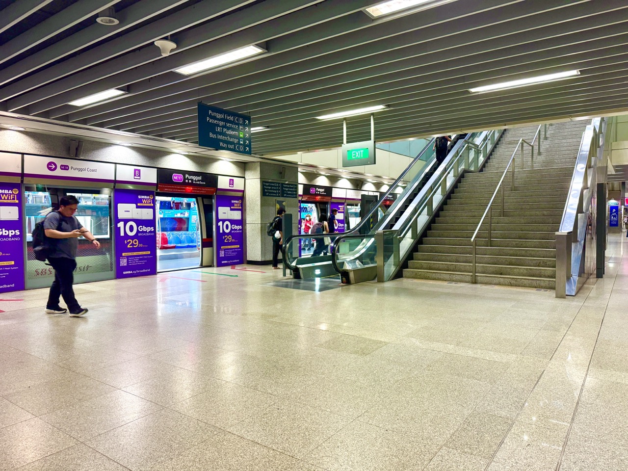 Passenger walking out of a train at Punggol MRT station in the evening.