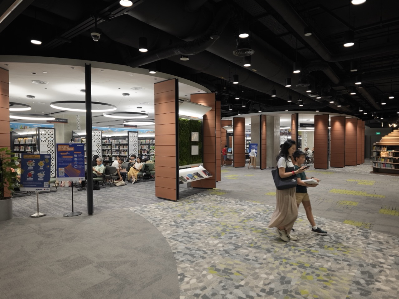 Adults and children reading inside the National Library Building in Singapore