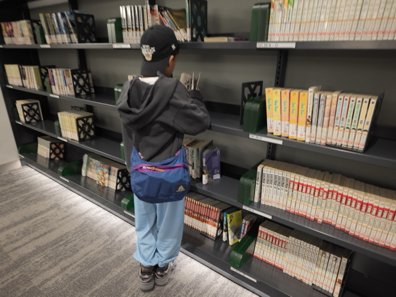Child reading a book inside the National Library Building in Singapore.