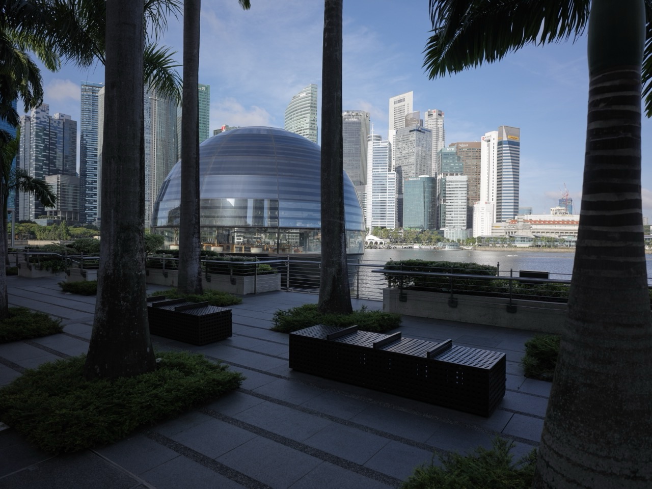 Round Apple Marina Bay Sands store on the waterfront with the financial district and The Sail in the background
