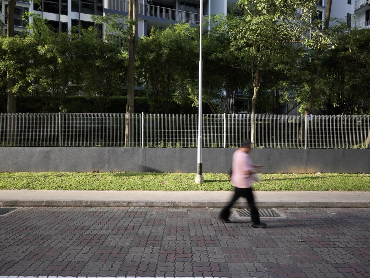 Man walking along a side road behind Parc Centros condominium in Punggol, Singapore