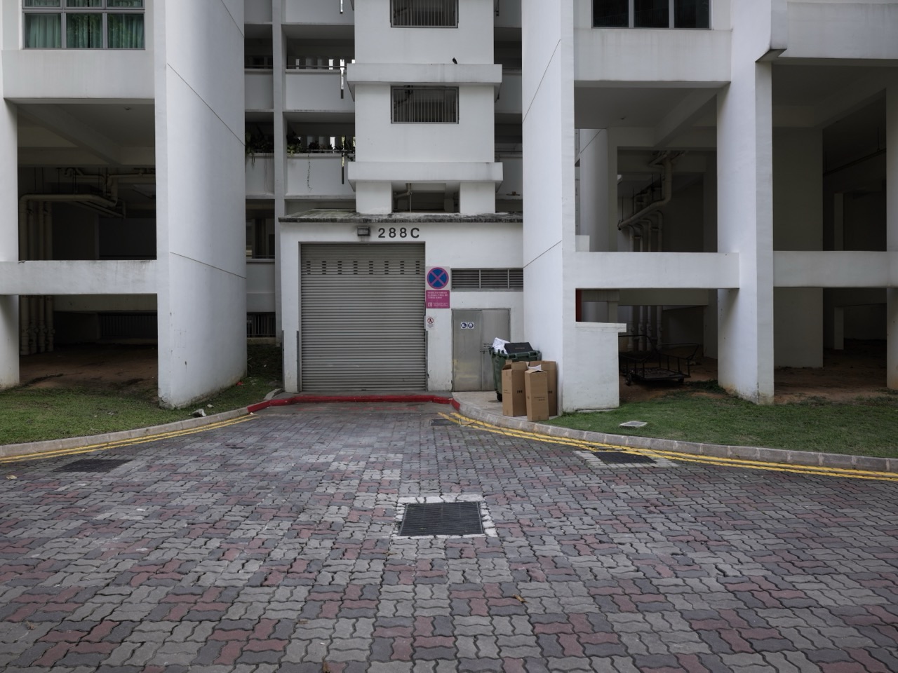 Side road beside a Punggol HDB block used for refuse collection access in Singapore