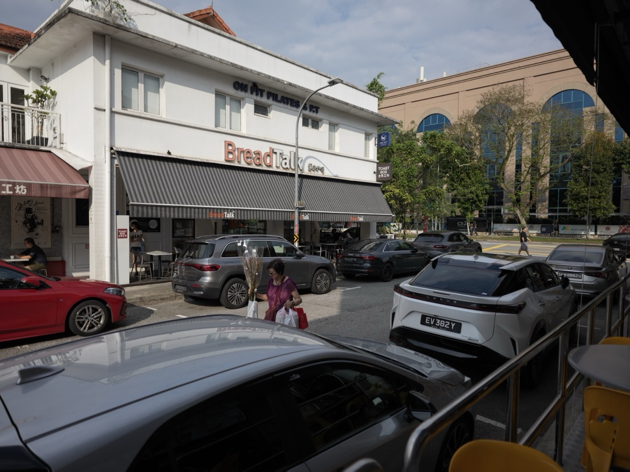 Cafés, shops, parked cars and the road along Sixth Avenue in Bukit Timah, Singapore