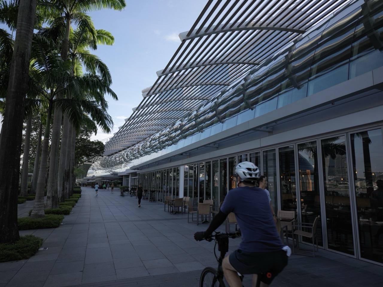 Cyclist on the waterfront promenade outside The Shoppes at Marina Bay Sands