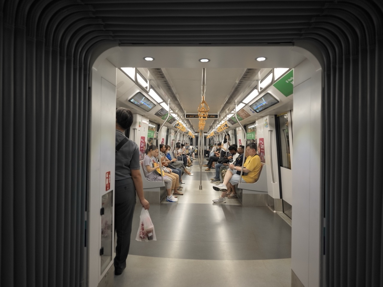 Seated passengers using smartphones inside a Singapore MRT train