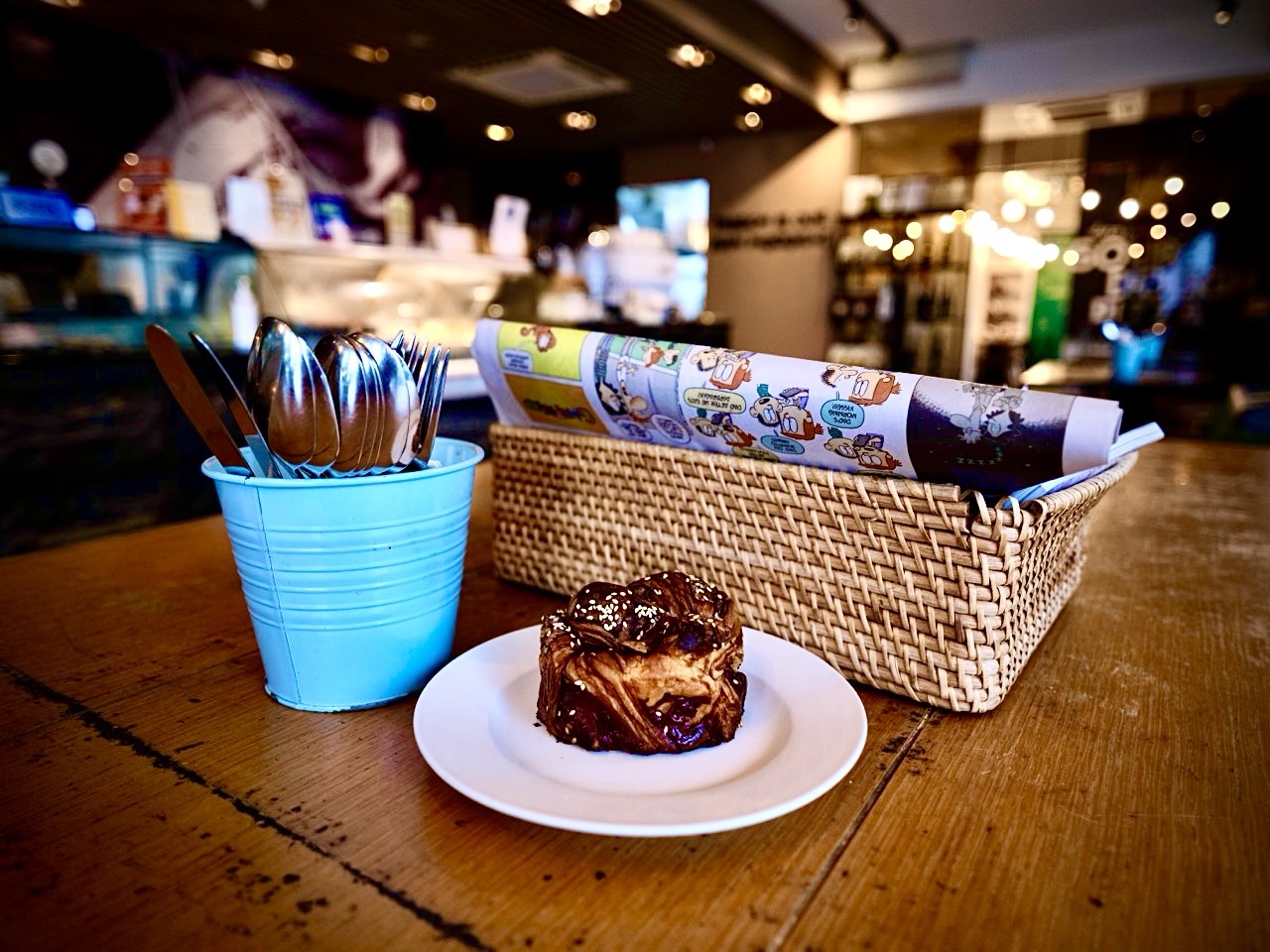 Coffee and cakes with cutlery and reading material at a café in Namly, Bukit Timah.