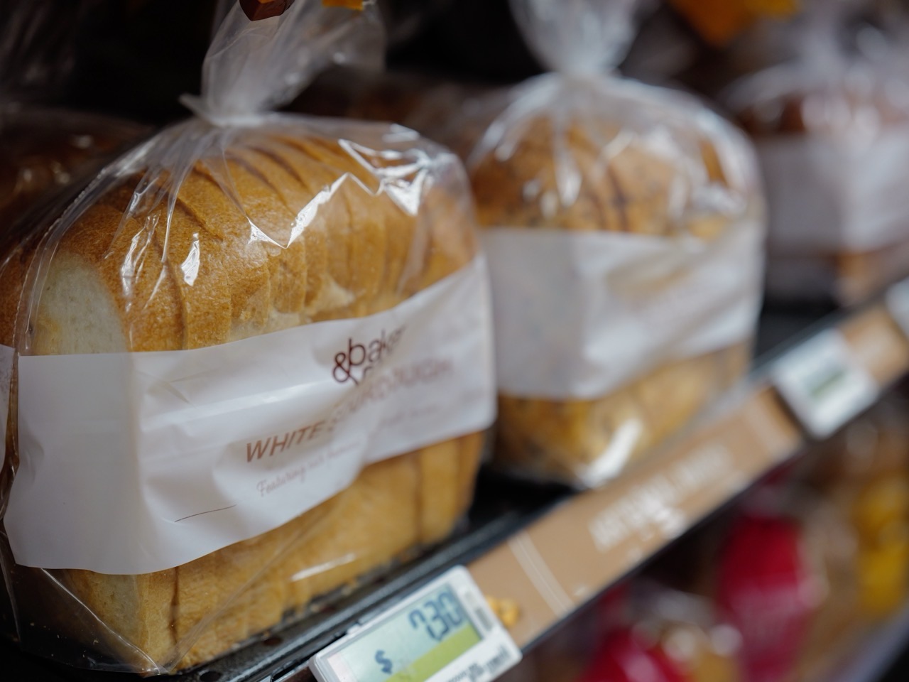 Packaged sliced bread displayed on a supermarket shelf with a visible price tag.