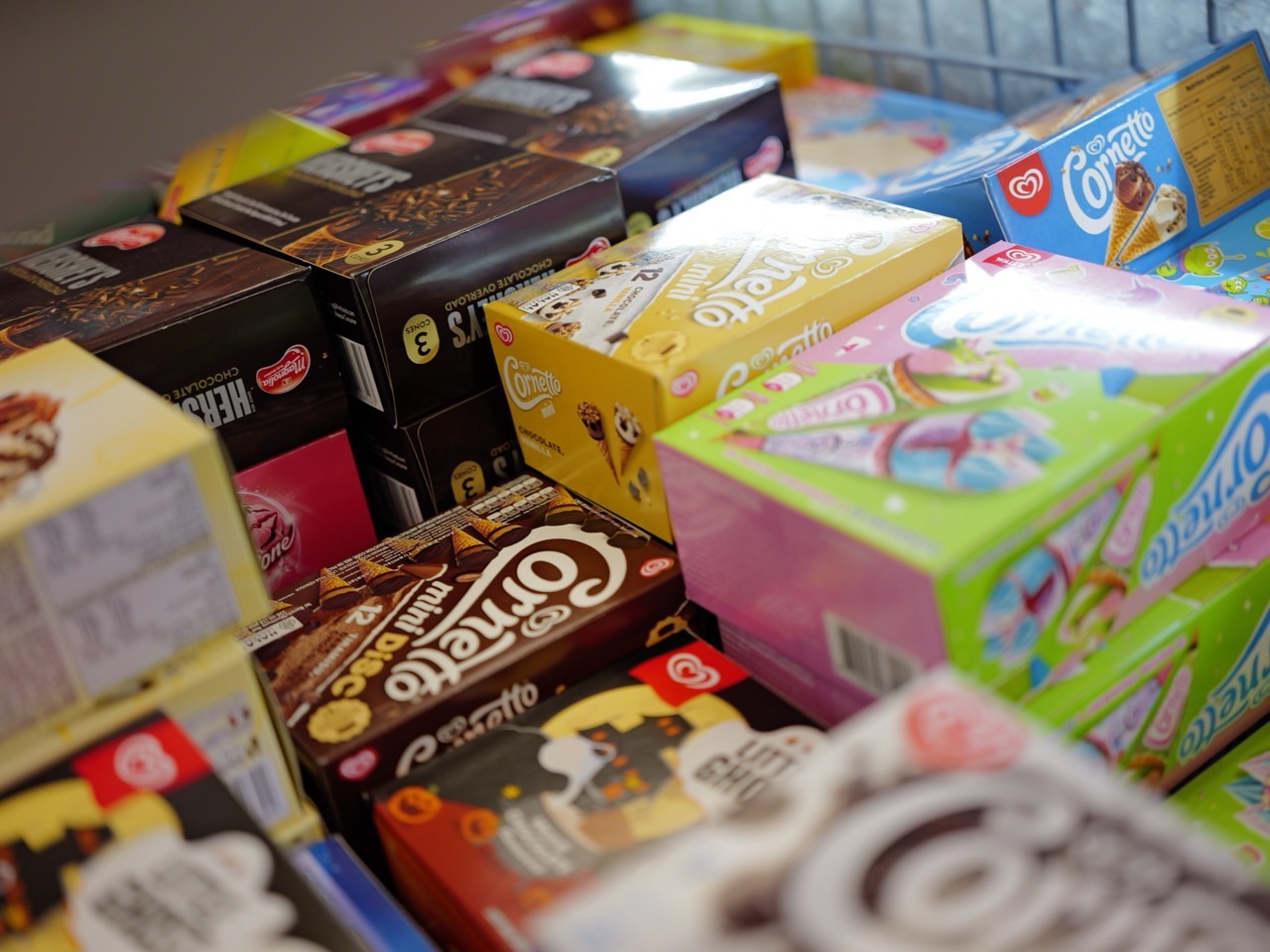 Boxes of ice cream displayed in a supermarket freezer section.