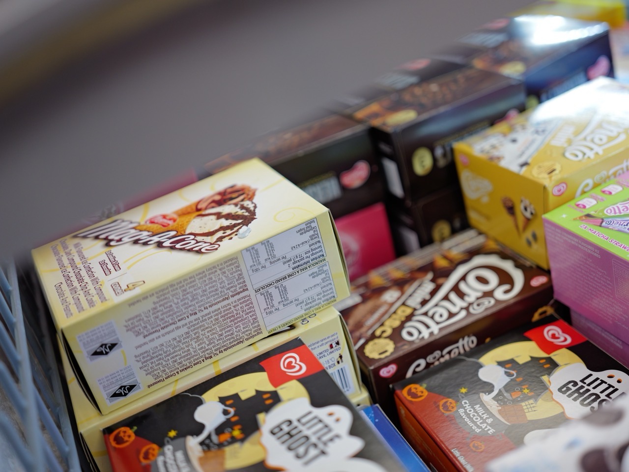 Boxes of ice cream displayed in a supermarket freezer section.