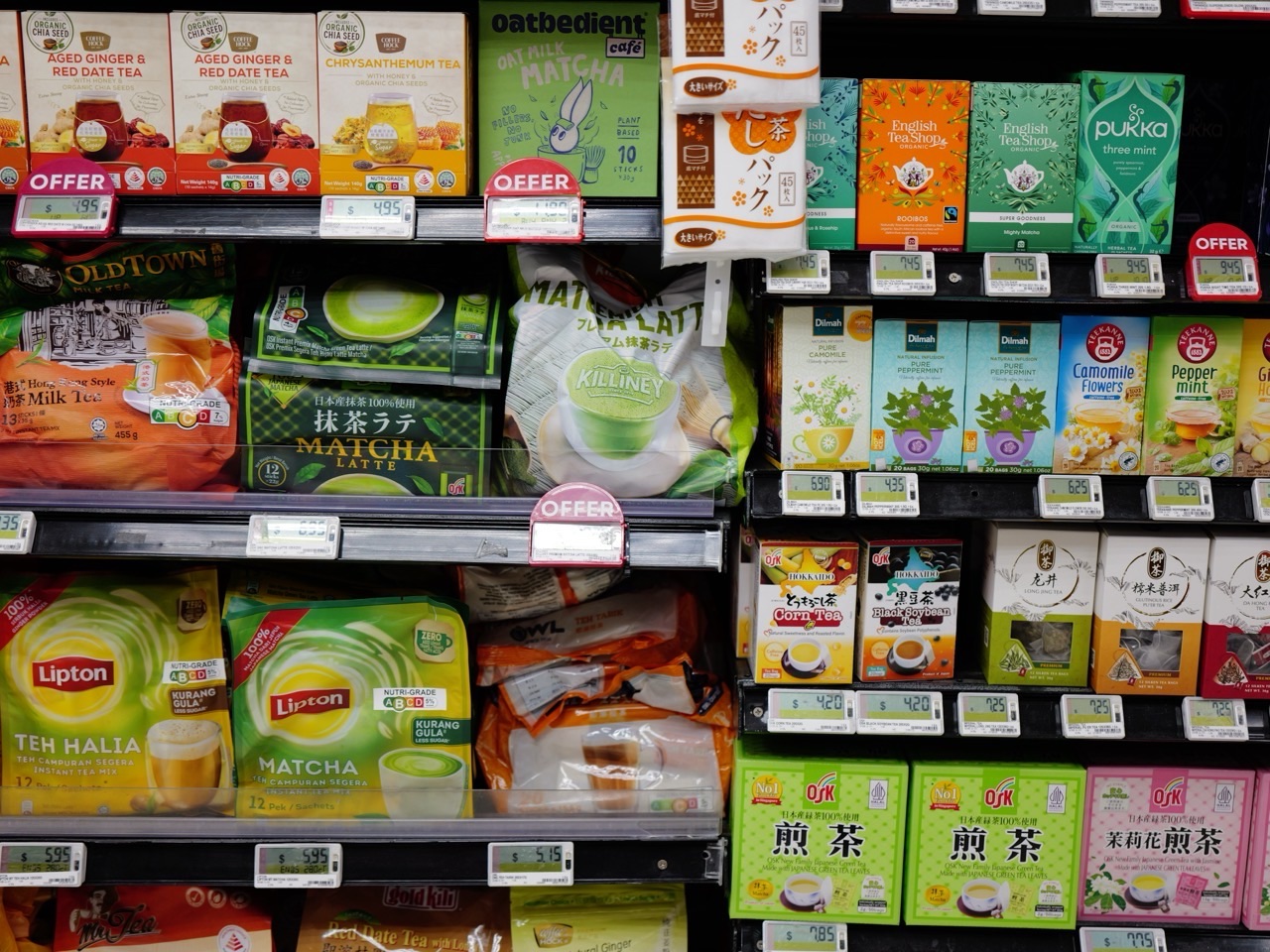 Tea products displayed on a supermarket shelf with visible prices.
