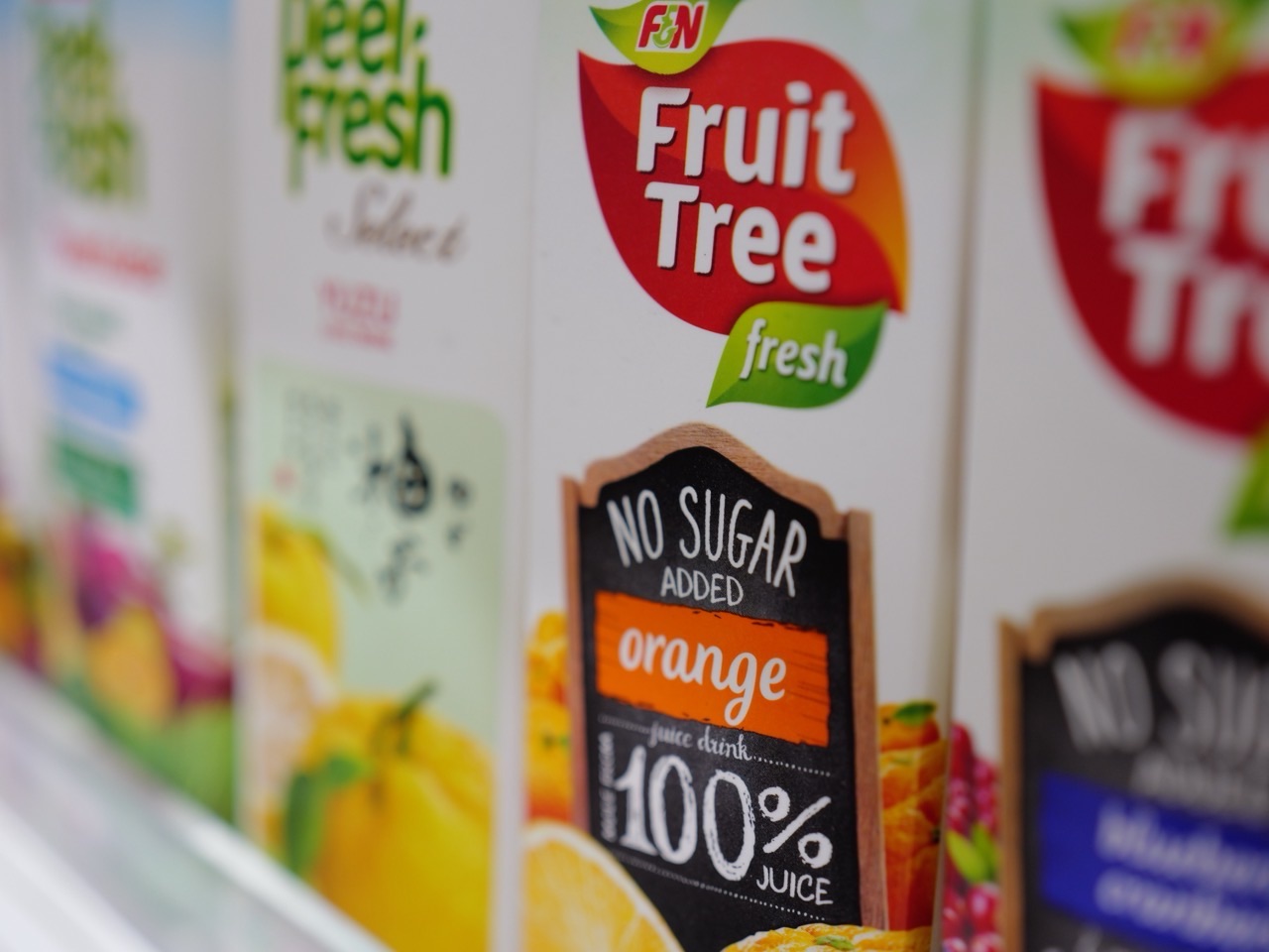 Fruit juice products displayed on a supermarket shelf.