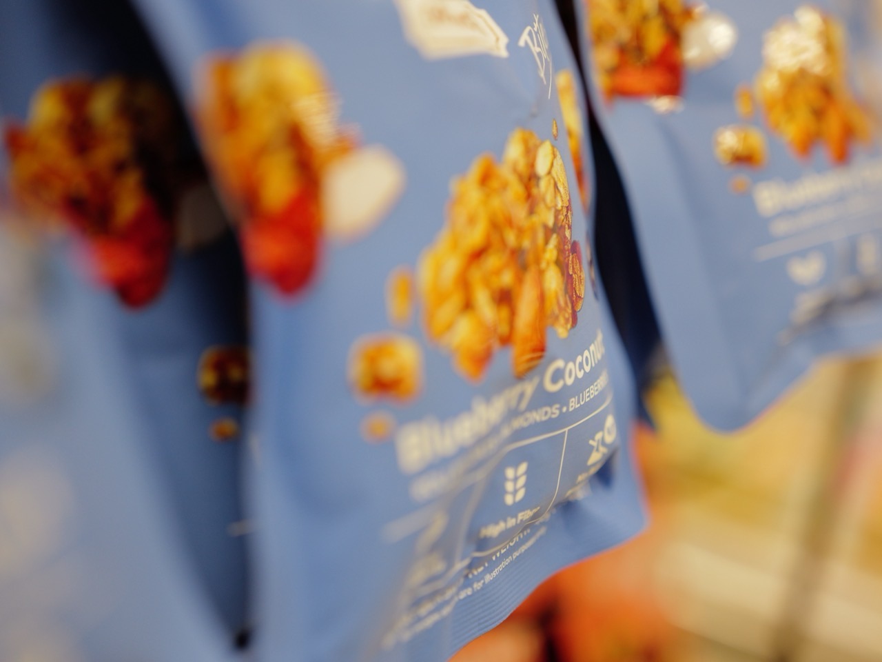 Muesli and nuts in retail packaging on a supermarket shelf.
