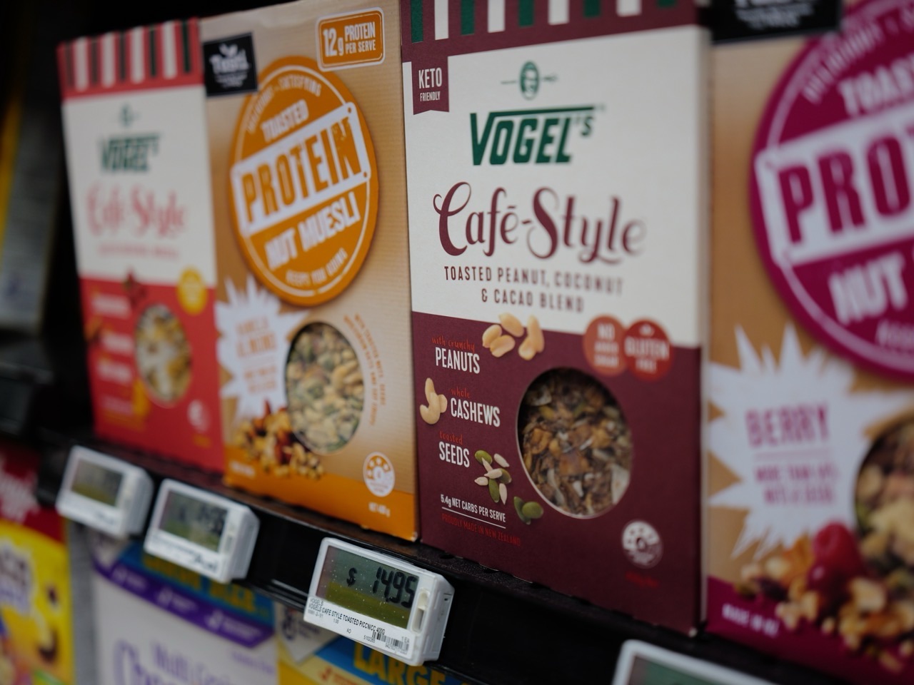 Boxes of muesli displayed on a supermarket shelf with visible prices.
