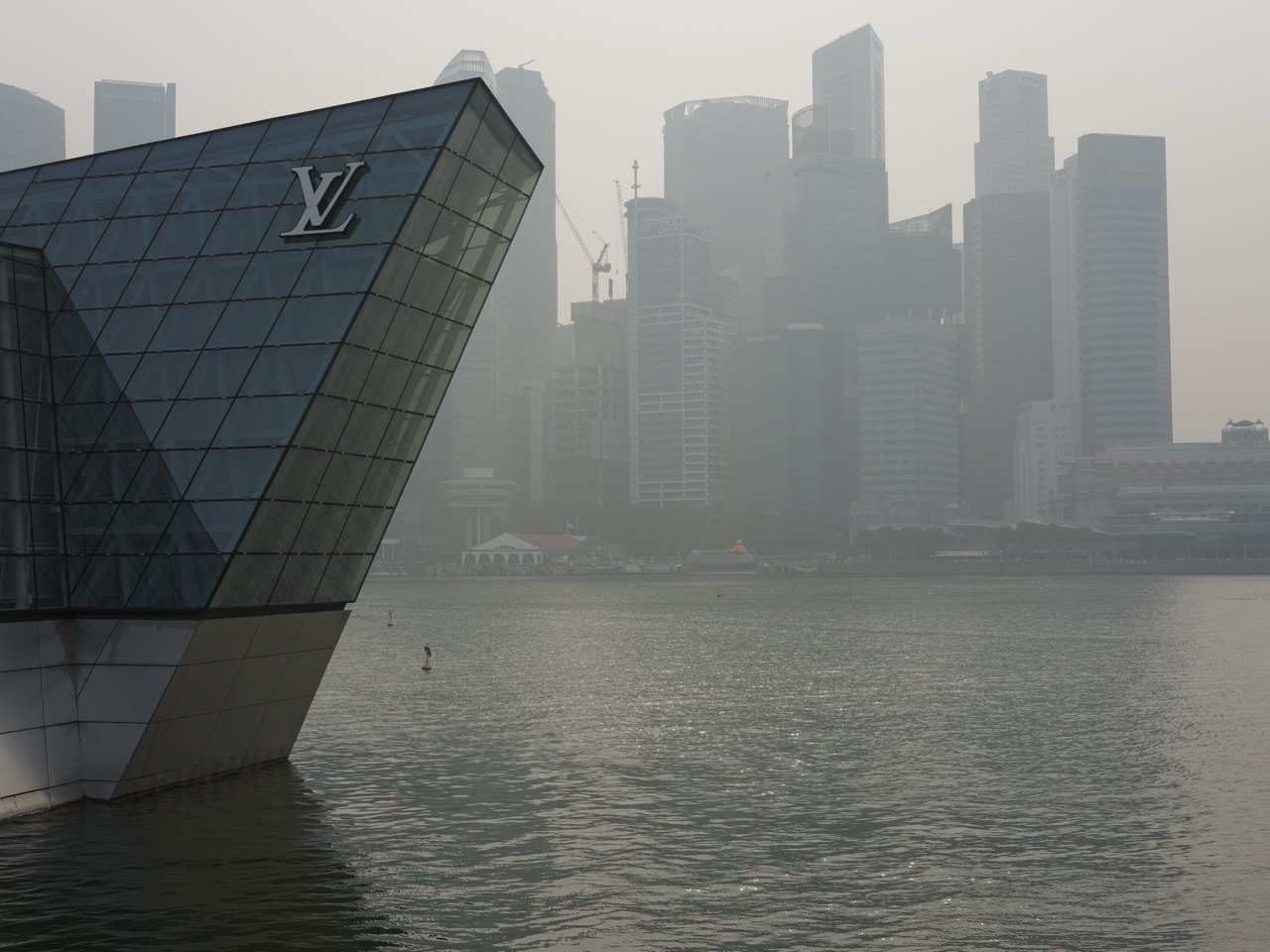 Hazy Singapore skyline with Louis Vuitton Island Maison on the left, viewed from Marina Bay Sands.