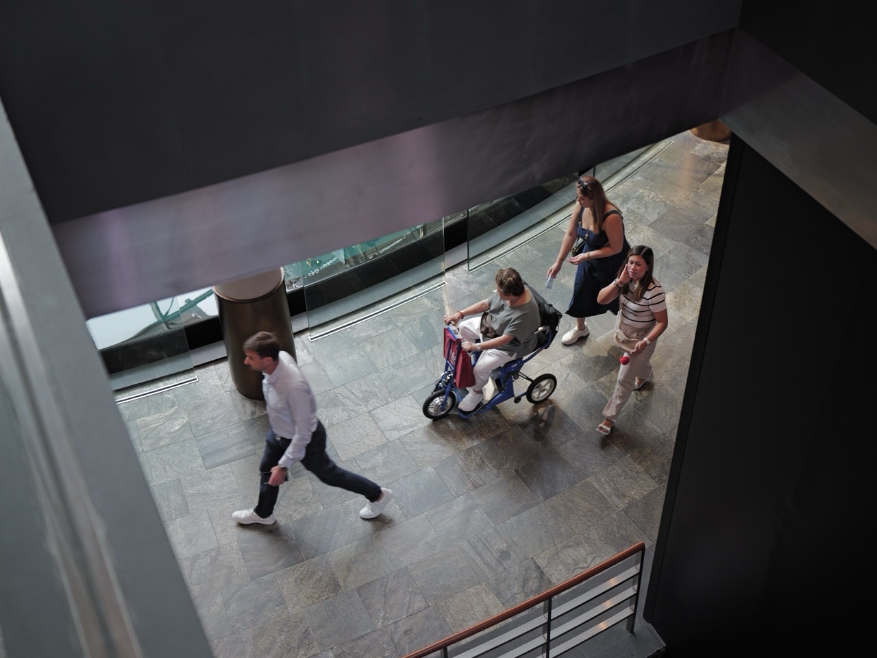 A visitor using a personal mobility vehicle among shoppers at The Shoppes at Marina Bay Sands.