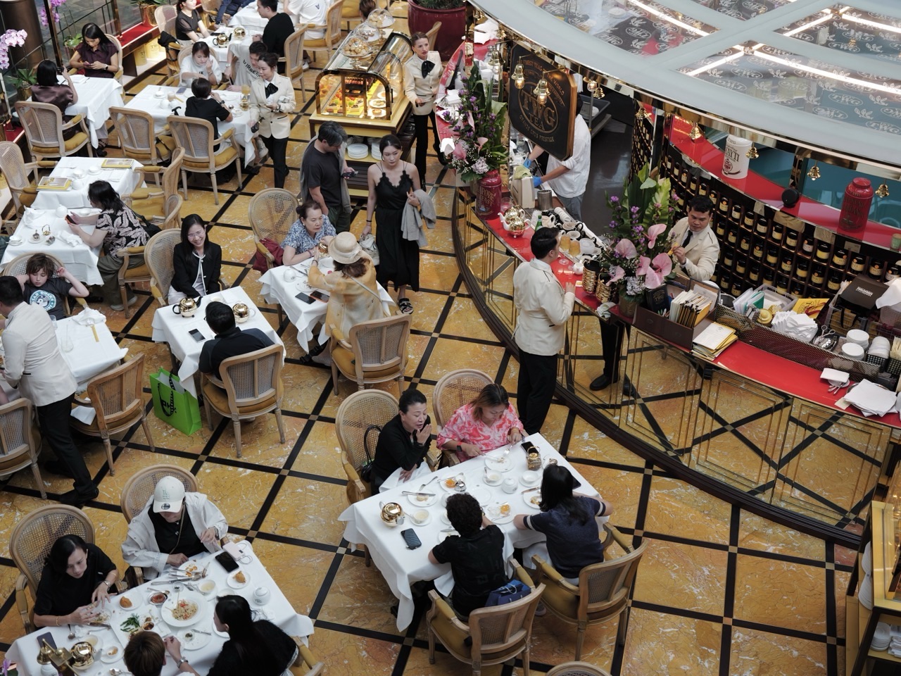 Diners talking during tea time at a Marina Bay Sands restaurant, seen from above.