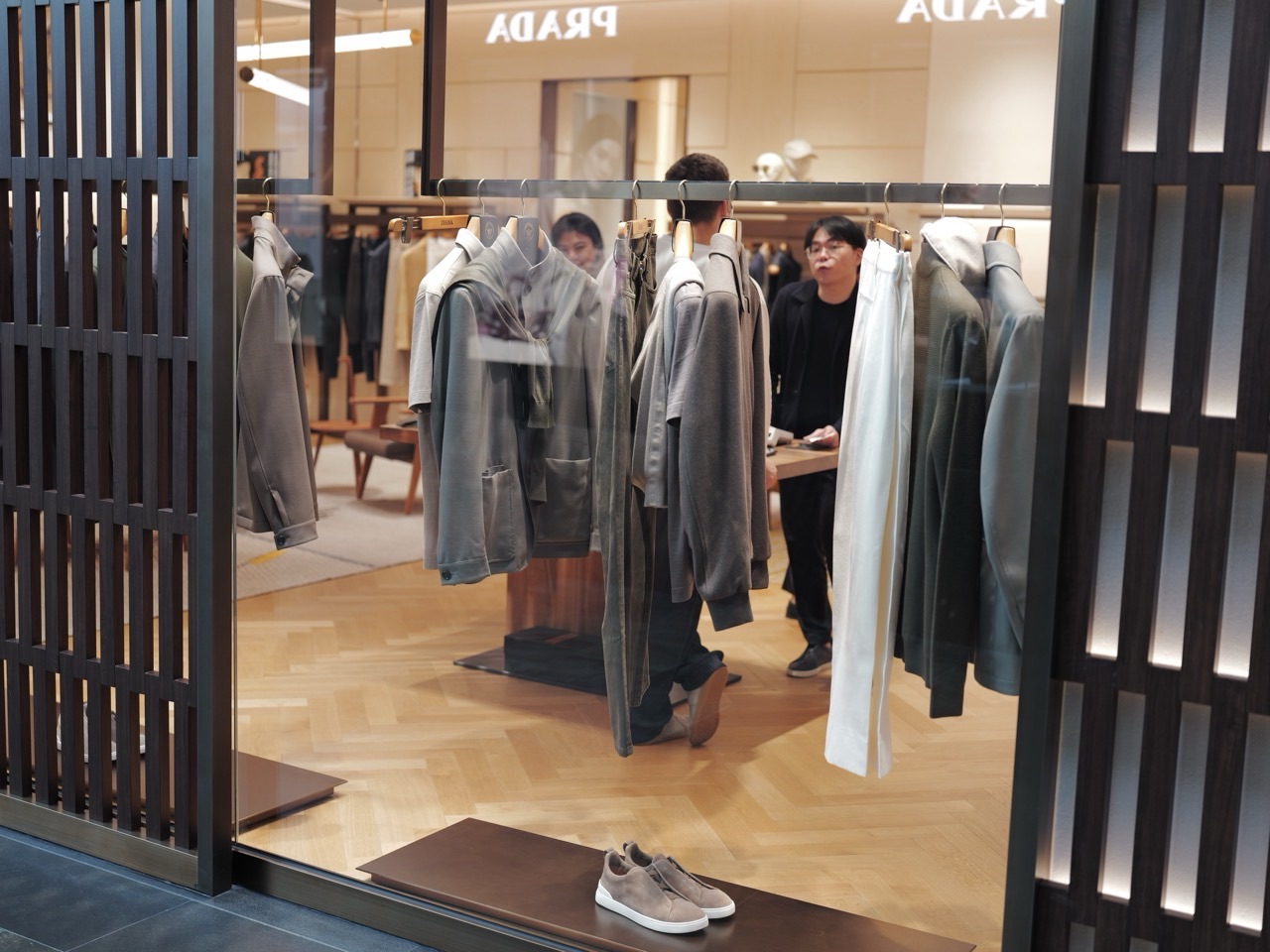 Staff serving customers behind a shop window, with a display rack in front, at Marina Bay Sands.