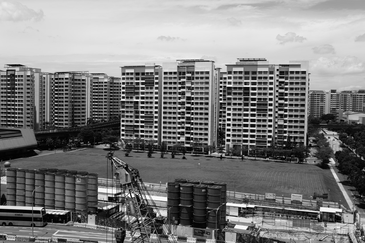 Construction near Punggol MRT with an open field and HDB flats in the background.