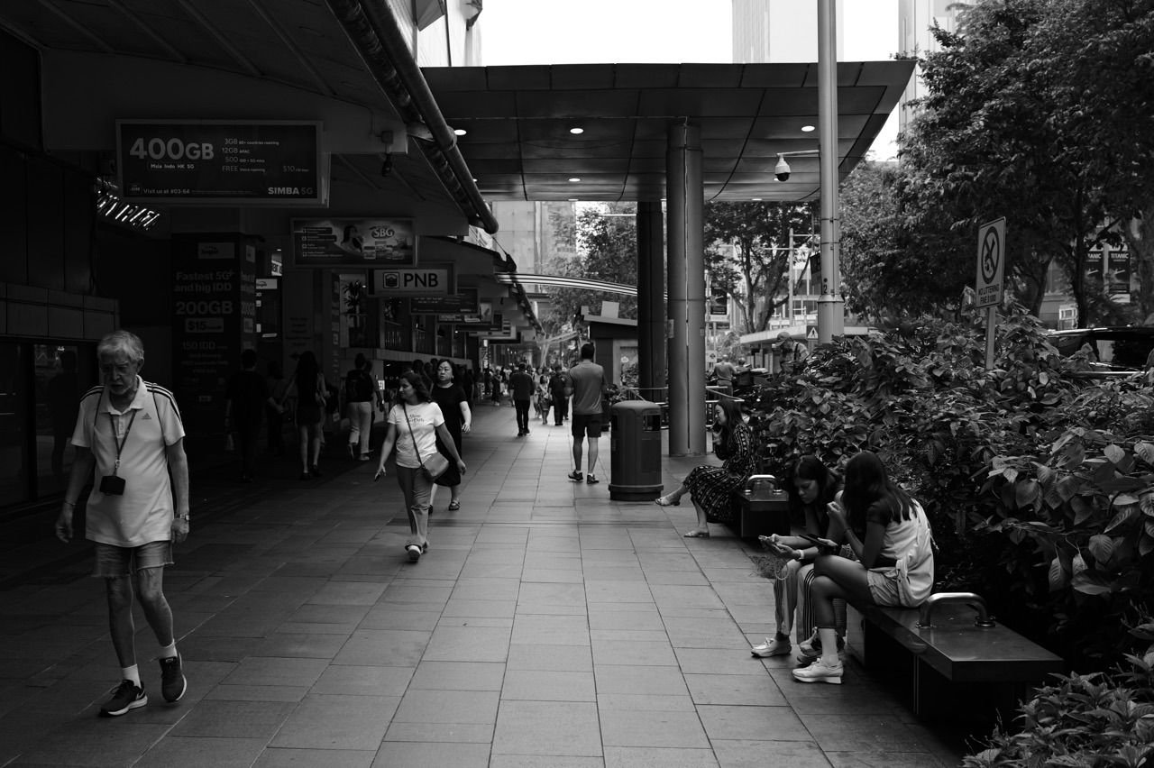 Pedestrian walkway with seating outside Orchard Plaza in Singapore.