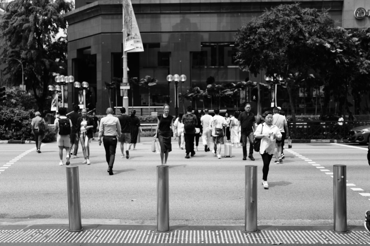 Pedestrians crossing Orchard Road in Singapore's shopping district.