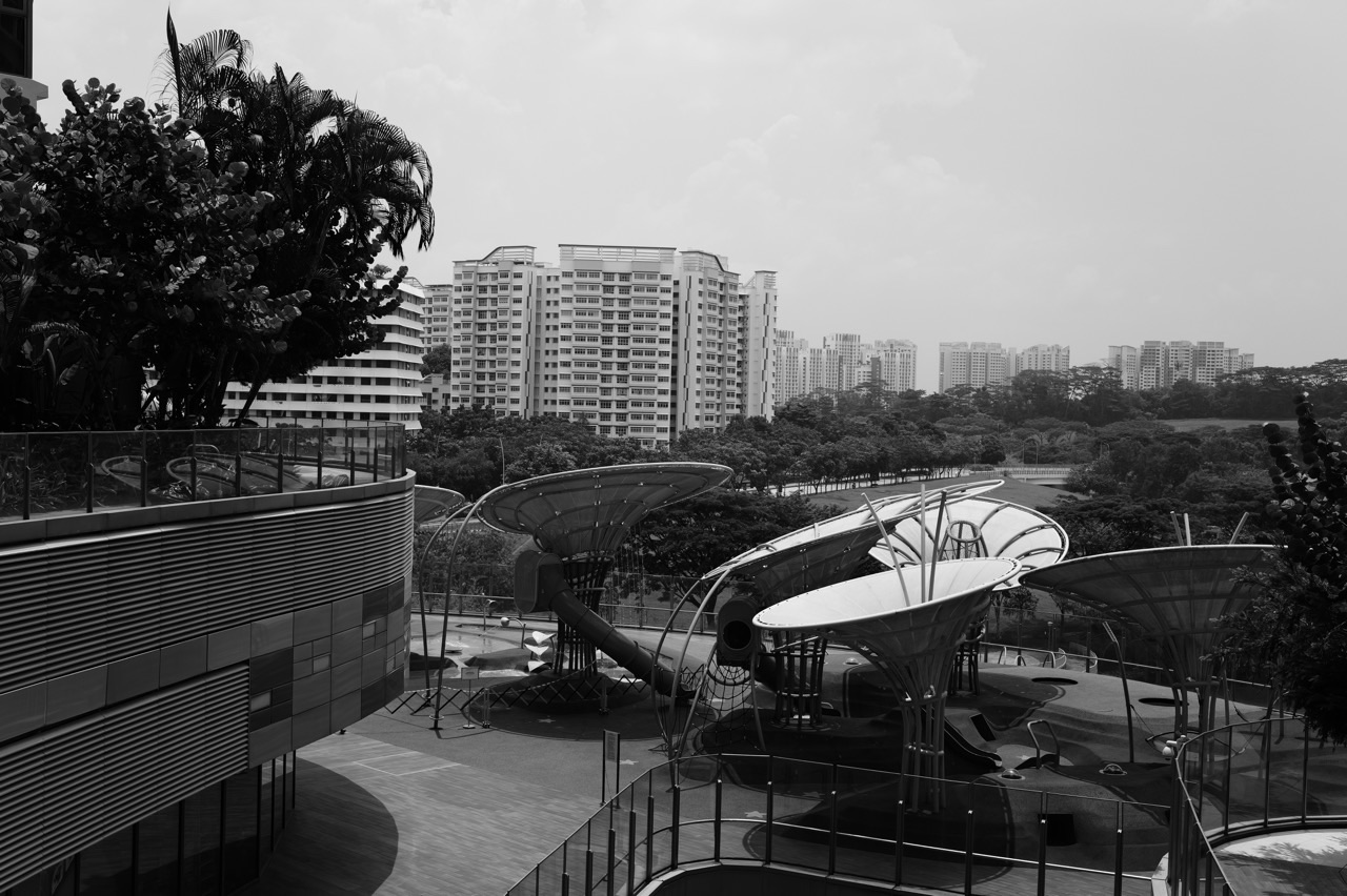 Exterior of Waterway Point in Punggol with children at the water playground and nearby buildings in the background.