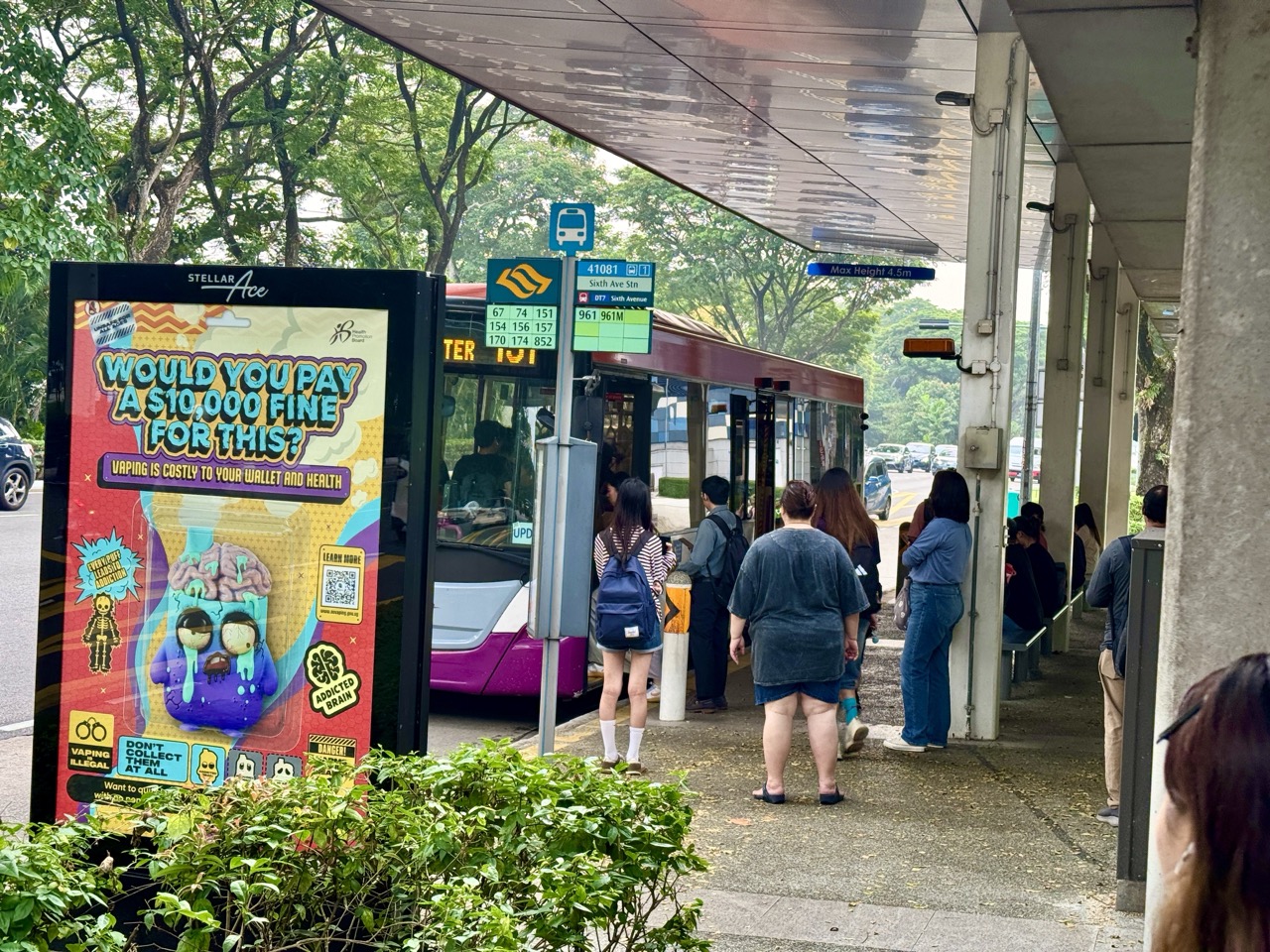 People queuing to board a bus at a bus stop near Sixth Avenue MRT station in Singapore.
