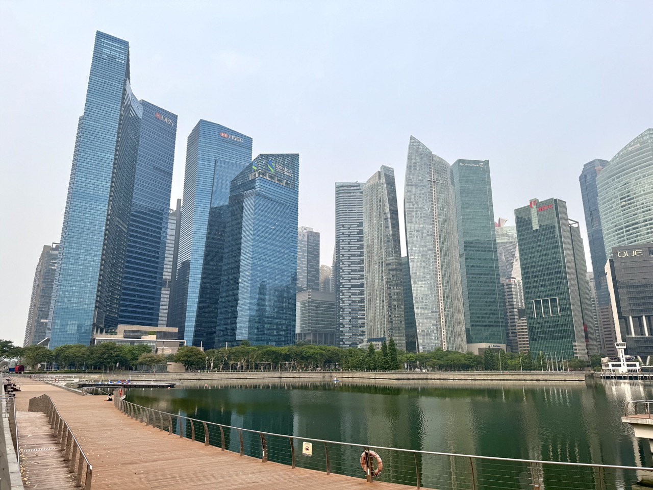 Singapore financial district skyline viewed from the waterfront boardwalk outside Marina Bay Sands.